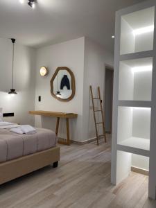 um quarto com uma cama e um espelho na parede em Olea White em Skiathos