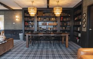 een eetkamer met een tafel en stoelen in een bibliotheek bij Hunter Lodge, a Bluebird by Lark in Hunter