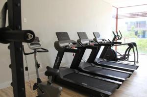 a row of tread machines in a gym with a phone at ILE de Pipa Resort Quarto Superior Frente Piscina in Pipa
