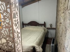 um quarto com uma cama num quarto em Casa de campo rústica em Tandil