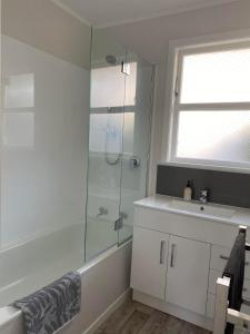 a bathroom with a shower and a sink at Lovely Newly Renovated Home in Hamilton