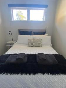 a bedroom with a bed with a black blanket on it at Lovely Newly Renovated Home in Hamilton