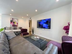 sala de estar con sofá y TV en la pared en Hollywood Purple Habitat, en Los Ángeles