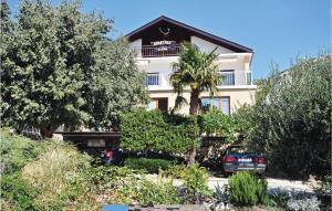 a large white building with a tree in front of it at Apartment Alojzija Stepinca Ii in Starigrad-Paklenica