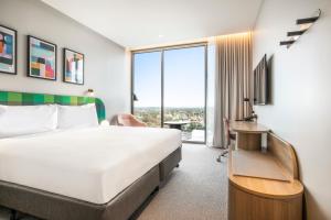 a hotel room with a bed and a large window at Holiday Inn Werribee, an IHG Hotel in Werribee