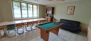 a room with a ping pong table and a couch at la maison de l'Harmadas in Parigné-lʼÉvêque