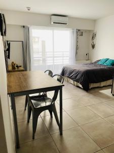 a room with a table and a bed and a bedroom at Hermoso Monoambiente en Rosario in Rosario