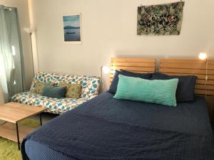 a bedroom with a blue bed and a couch at Funky Urban Studio near UNR in Reno