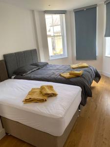 two beds in a room with two towels on them at Luxury Flat Near Greenwich Park in London