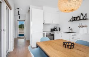 a kitchen with a wooden table and blue chairs at Kysthusene, Lejl 7 in Slagelse