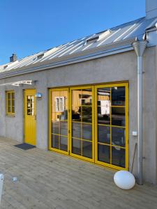 un edificio con puertas amarillas y muchas ventanas en Casa Annie & Nadja - Toppmodernt centralt i Borgholm en Borgholm