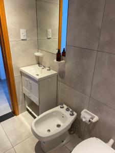 a bathroom with a white toilet and a sink at Hermoso Monoambiente en Rosario in Rosario