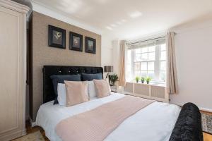 - une chambre avec un grand lit blanc et une fenêtre dans l'établissement Beautiful Two Bedroom Apartment Nearby Hyde Park, à Londres
