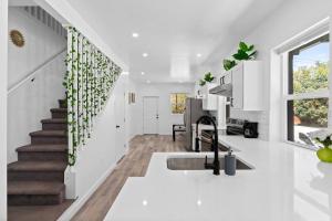 a white kitchen with white walls and a staircase at Day Dream Denver Stay in Denver