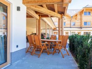 taras ze stołem i krzesłami z drewna w obiekcie AlmApARTment Mauterndorf Pichl 8-2 w mieście Mauterndorf
