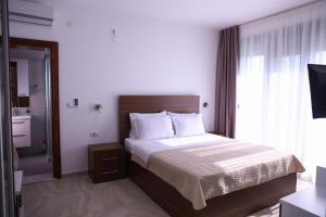 - une chambre avec un lit et une grande fenêtre dans l'établissement Hamptons Village Apartments Ada Bojana, à Ulcinj