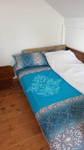 Bett mit blauer Bettdecke und Kissen darauf in der Unterkunft Vikendica Drina in Ljubovija