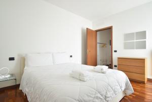 a white bedroom with a large white bed with towels on it at Villafranca Relaxing apartment in Villafranca Padovana