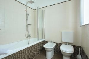 a bathroom with a toilet and a tub and a sink at Villafranca Relaxing apartment in Villafranca Padovana