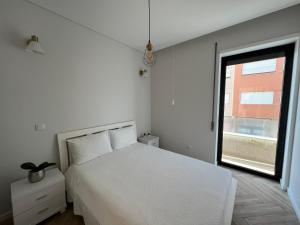 een slaapkamer met een wit bed en een raam bij Custódio Ocean View in Praia de Mira