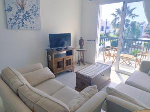 a living room with two couches and a tv at Sunset Green 03 in Paphos City
