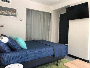 a bedroom with a blue bed and a window at Funky Urban Studio near UNR in Reno