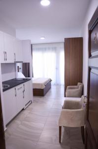 a room with a kitchen and a bedroom with a bed at Hamptons Village Apartments Ada Bojana in Ulcinj