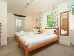 two twin beds in a room with a mirror at Ferry View in Dartmouth