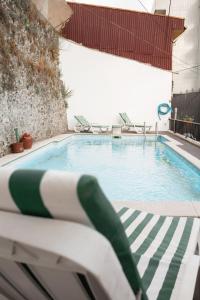 uma piscina com espreguiçadeiras num edifício em Casa D'Abó em Peso da Régua