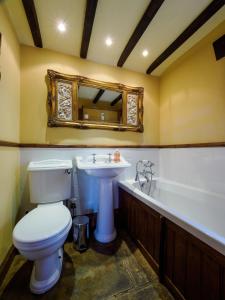 a bathroom with a toilet and a sink and a tub at Sweet knoll cottage in Buxton