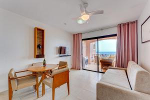 een woonkamer met een tafel en een bank bij Sol Sun Beach in Adeje
