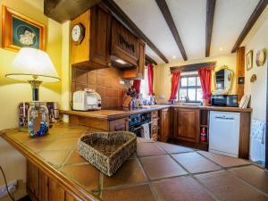 una cocina con armarios de madera y una mesa con lámpara. en Sweet knoll cottage, en Buxton