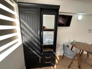 a black cabinet with a mirror in a room at TinyApartments - estudio pleno centro Concepción in Concepción