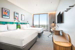 a hotel room with two beds and a desk at Holiday Inn Werribee, an IHG Hotel in Werribee