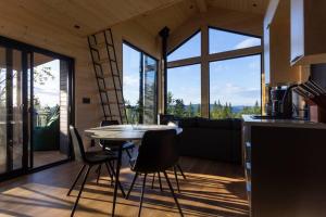 cocina y sala de estar con mesa y sillas en Le Nørr - Maelström (CITQ #302901), en Lac-Beauport
