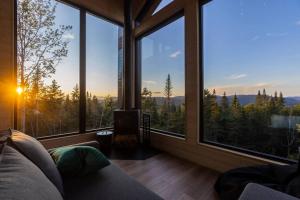 a room with large windows with a view of the mountains at Le Nørr - Maelström (CITQ #302901) in Lac-Beauport