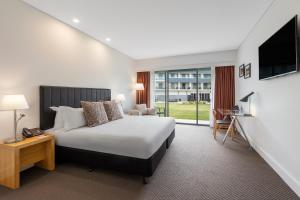 勒弗戴尔Rydges Resort Hunter Valley的一间带床和电视的酒店房间
