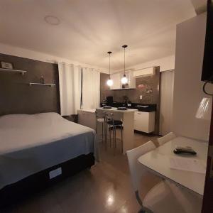 ein Schlafzimmer mit einem Bett und eine Küche mit einem Tisch in der Unterkunft STUDIO 301 | WIFI 600MB | RESIDENCIAL JC, um lugar para ficar. in Belém