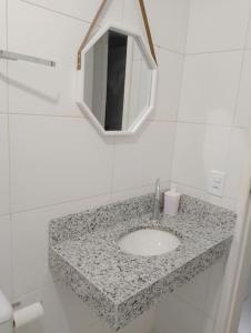 W łazience znajduje się umywalka i lustro. w obiekcie Apartamento no Condomínio Vila das Águas w mieście Estância