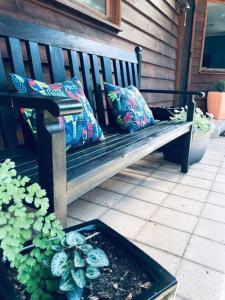 a wooden bench with two pillows on a patio at Snowcapped Peaks in Mount Beauty