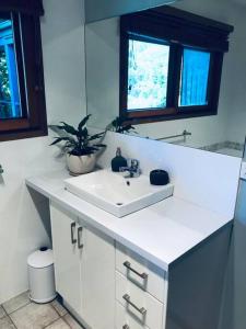 a bathroom with a white sink and a mirror at Snowcapped Peaks in Mount Beauty