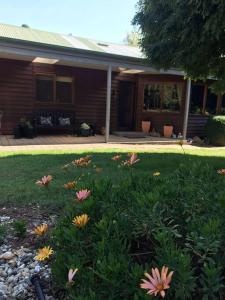 a yard with flowers in front of a house at Snowcapped Peaks in Mount Beauty