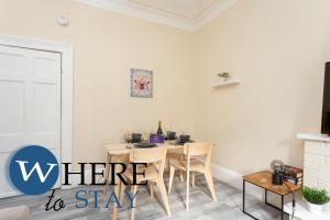 a dining room with a table with chairs and a tv at Brunswick road Lovely 2 Bed Apartment in Edinburgh +16 photos
