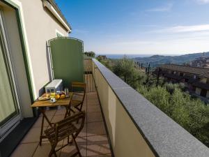 a balcony with a table and chairs and a view at Gloria del Mare - swimming pool with nice sea view in Civezza