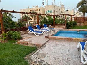 a group of blue lounge chairs next to a swimming pool at Serafy City Center Hostel and Pool for Foreigners Adults Only in Hurghada