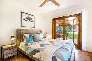 1 dormitorio con cama y ventana en Sunbaker Pet Friendly Awards Finalist 4 Mins Walk to Culburra Beach, en Culburra Beach