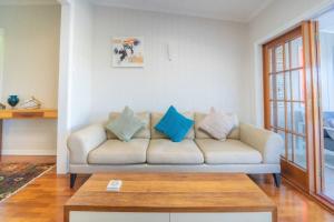 a living room with a couch with blue pillows at West End Luxury 4B3B Home w Parking and Home Pod Music System M9 in Brisbane +71 photos