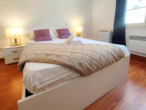 duże łóżko w sypialni z 2 lampami w obiekcie Grimaldi Centrale 5 Pers Wi-Fi AC w Nicei