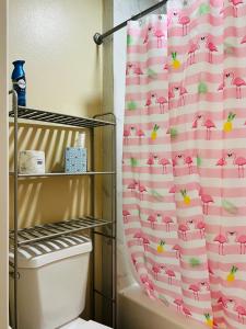 a bathroom with a pink shower curtain with a toilet at Apartment near TPA Airport in Tampa