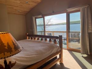 een slaapkamer met een bed en uitzicht op het water bij Deepwater Lodge Chicaugon Lake! 